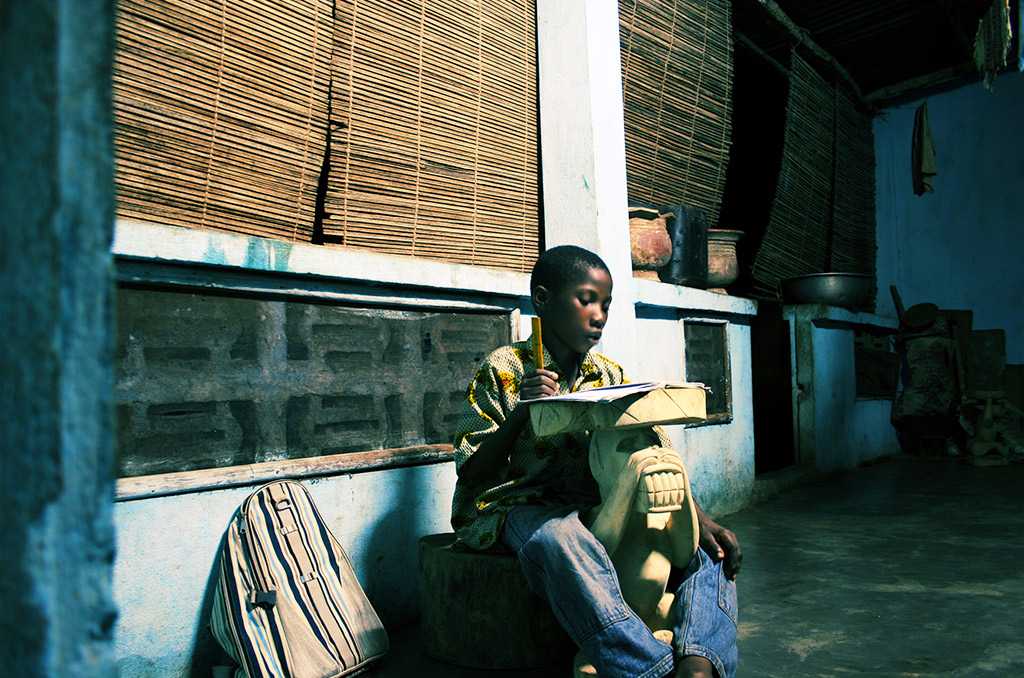 En Afrique, l’électrification reste une idée neuve | Journal des Activités Sociales de l'énergie | African boy doing schoolwork late night at home ©peeterv