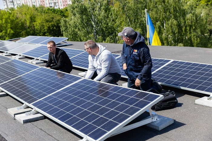 Intervention d'un bénévole de l'ONG Électriciens sans frontières en Ukraine, où l'association a déjà déployé plus d’une centaine de solutions hybrides (panneaux photovoltaïques, batterie et groupe électrogène) à travers le pays. ©Électriciens sans frontières